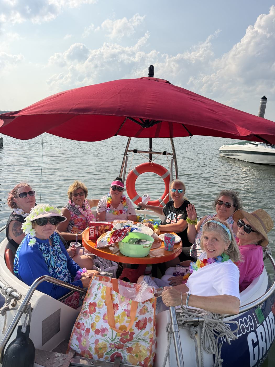 A group waving from a GrubTub under the red umbrella